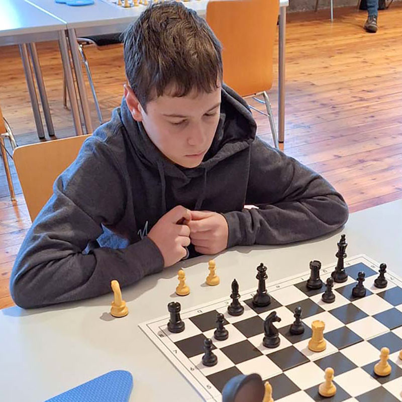 Junge, tief in Gedanken versunken, während er Schach spielt